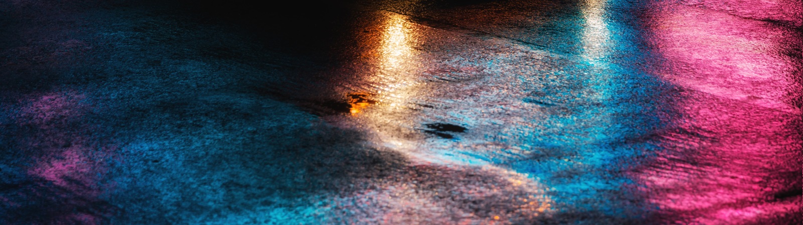 Wet street scene lit by coloured lighting